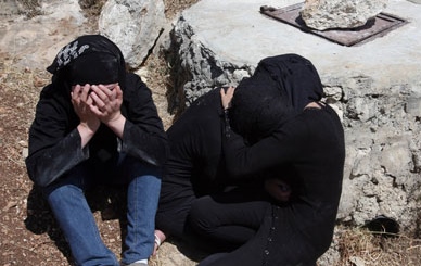 Sisters of Palestinian Aya Baradia, 21, who was a victim of honour killing, mourn next to the water well where her uncle threw her in the village of Surif near the West Bank city of Heron on May 21, 2011. – AFP